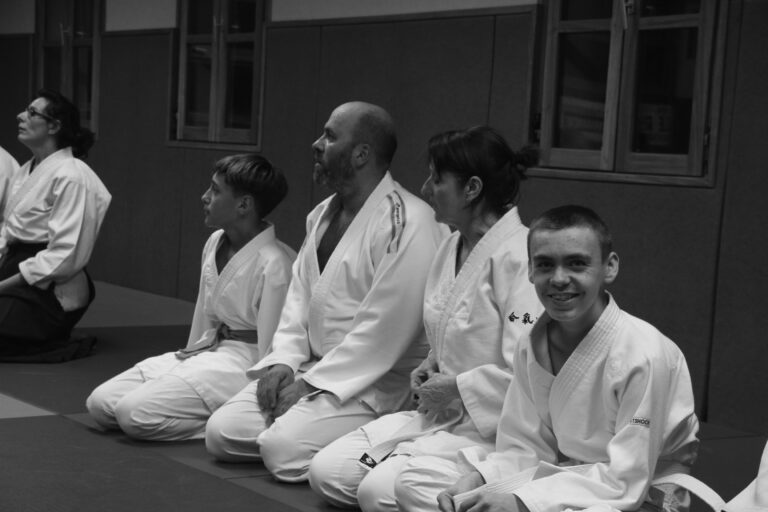 Pratiquants d'a&iuml;kido assis en seiza, align&eacute;s sur le tatami avant le cours